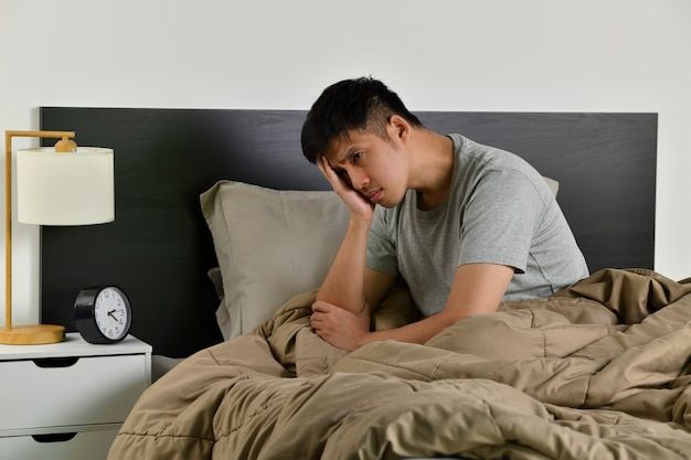 침대에 앉아 있는 남성