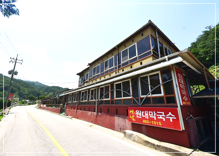 길가에 위치한 커다란 규모의 2층 한옥 스타일 인제 옛날원대막국수 건물 모습