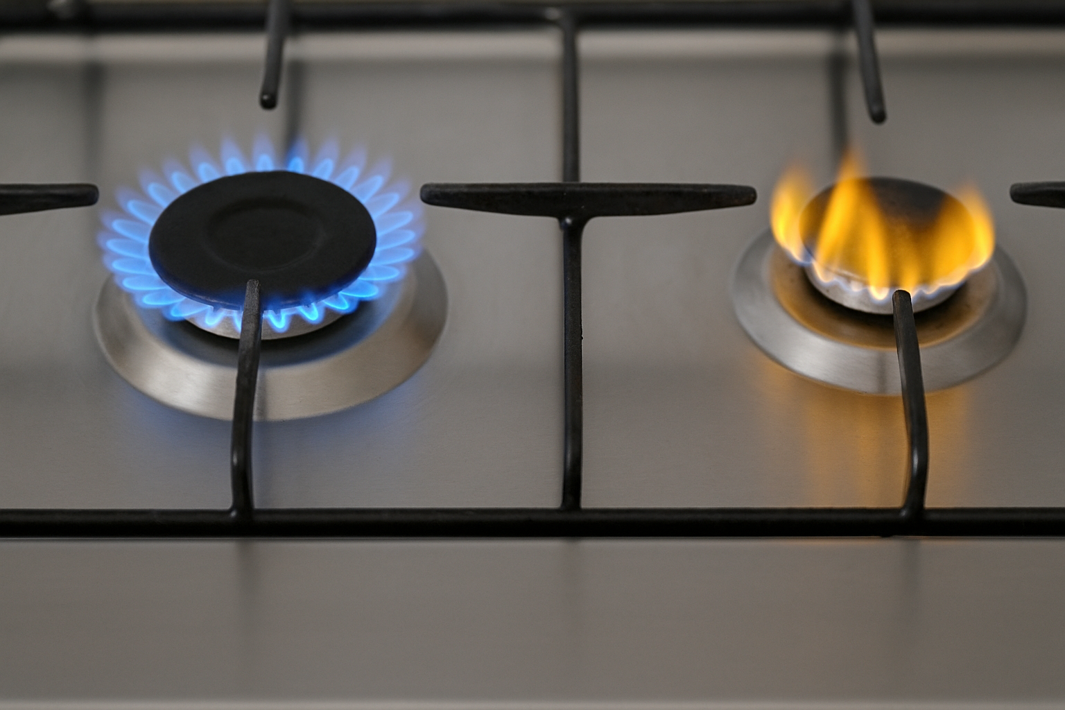 왼쪽 파란 불꽃은 정상, 오른쪽 노란 불꽃은 연소 불량을 시사하는 가스 버너 비교