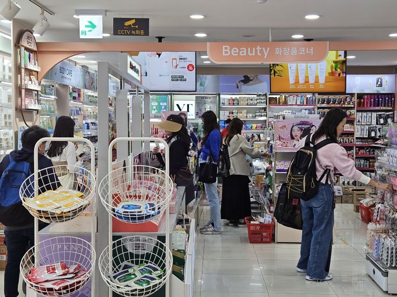 24일 서울 중구 다이소 명동역점 2층 뷰티 매장을 찾은 쇼핑객들이 제품을 살펴보고 있다.