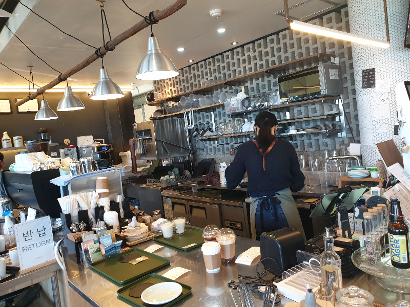 음료를 준비중인 바리스타와 그들이 일하는 공간