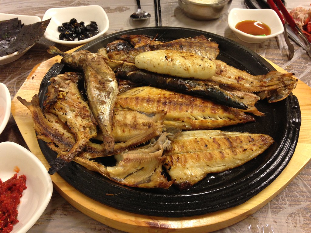 한국식으로 반찬이 놓인 밥상이며, 중앙에 여러 마리의 생선이 구이가 되어 놓여 있는 사진