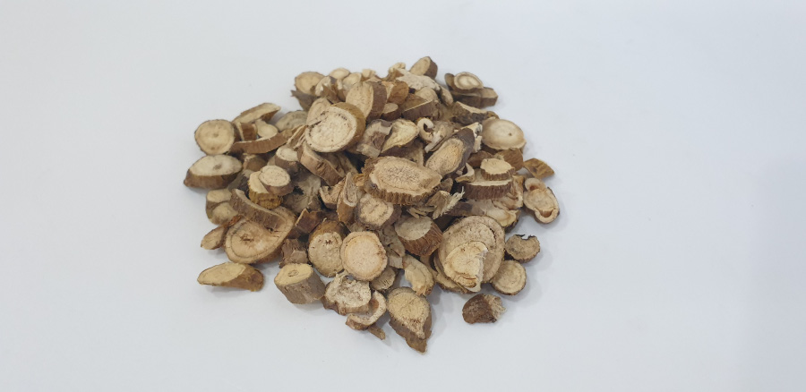 야생에서 채취를 한 고삼나무의 뿌리인 고삼을 깨끗하게 세척을 한 후에 건조시킨 것을 편으로 썰어서 하얀 바닥 위에 수북하게 쌓아두고 찍은 사진