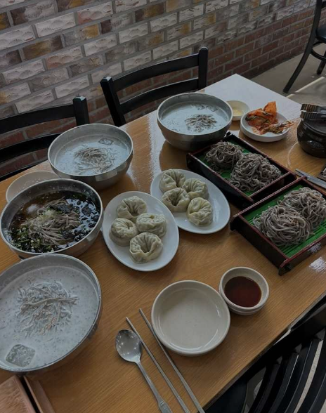 콩국수, 메밀소바, 만두 요리가 상에 놓인 사진