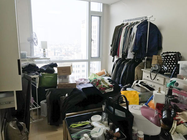 좁은 원룸에 건조대가 펼쳐져 옷이 널린 장면.