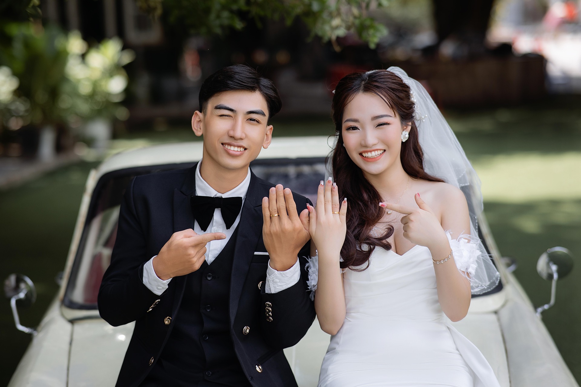 어느 부부가 결혼반지를 손으로 가르키는 사진