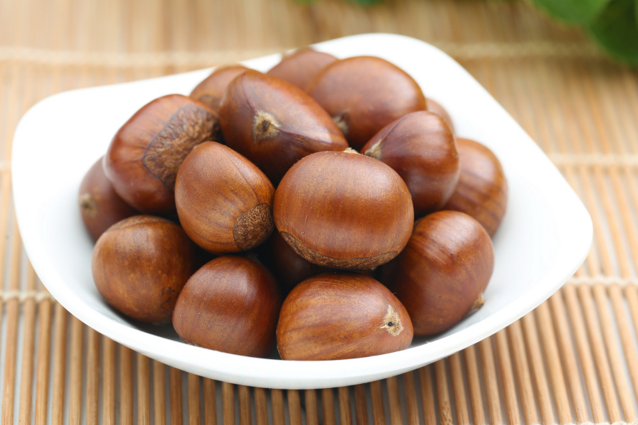 야생에서 채취를 한 밤을 깨끗하게 세척을 한 후에 대나무 깔판 위에 희고 네모난 그릇에 가득 담아두고 찍은 사진