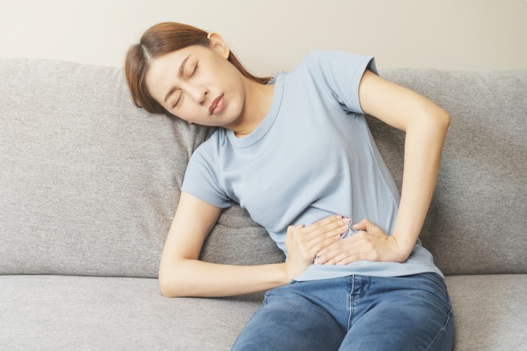 한-여성이-아랫배를-움켜-잡고-아파하고-있는-장면