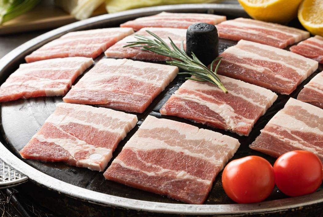 솥뚜껑 위에 올라가 있는 삼겹살과 오늘N 삼겹살찜쌈밥