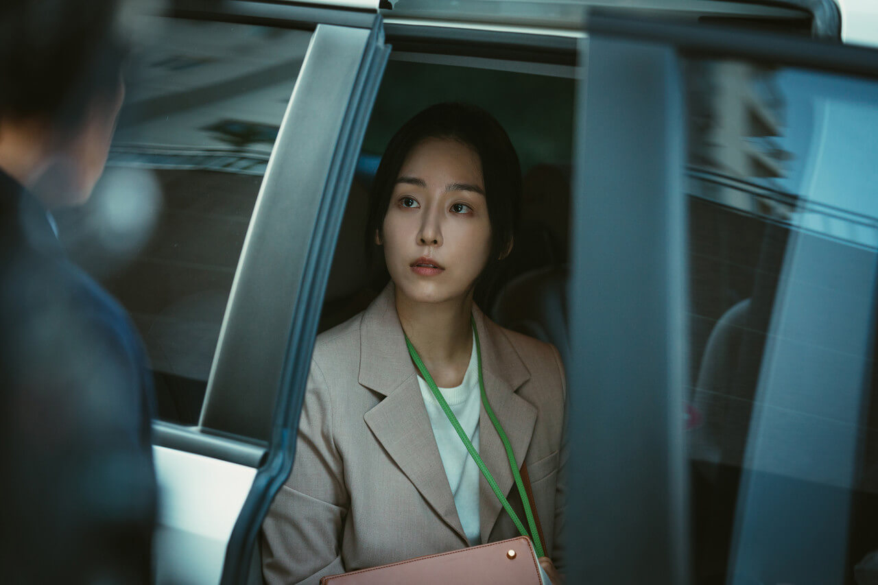 목걸이를 걸고 있는 여자가 차에 탄 채 문이 닫히고 있는 모습