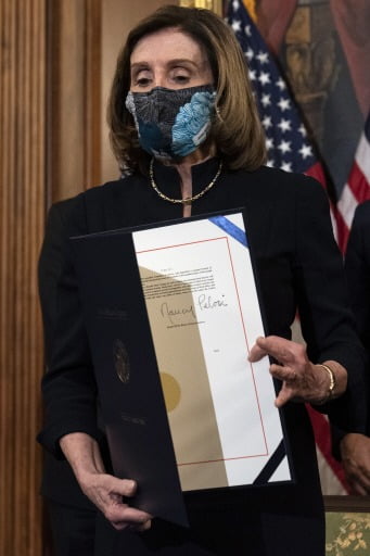 2021년 1월 장례식을 연상시키는 검은색 원피스를 입고 도널드 트럼프 당시 미국 대통령에 대한 탄핵소추안에 서명하는 낸시 펠로시 전 미 하원의장.