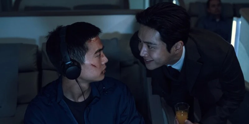 비행기 1등석에 해드폰을 낀채 귀공자를 마주보고 있는 마르코