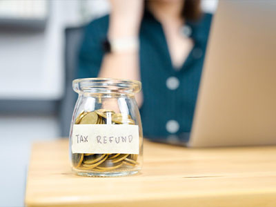 TAX REFUND 라벨이 붙은 유리 저금통, 세금 환급을 의미하는 이미지