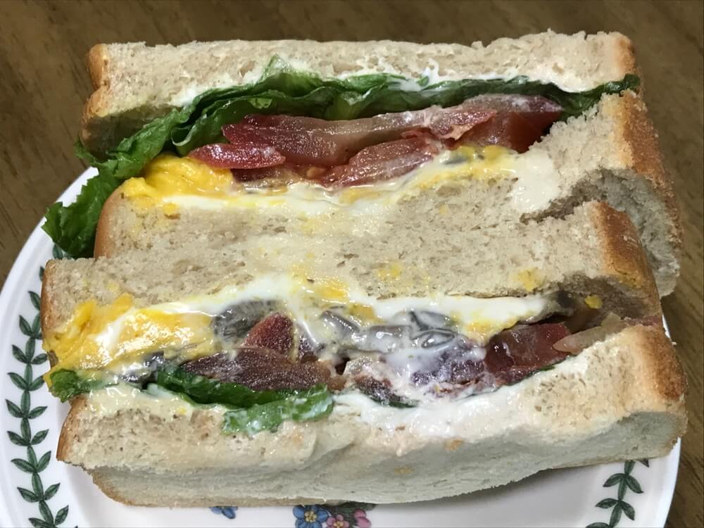 단호박 에그 샌드위치 모습입니다. 2조각이고, 식빵 사이에 단호박에그 샐러드, 토마토, 로메인, 양송이버섯이 들어있습니다.