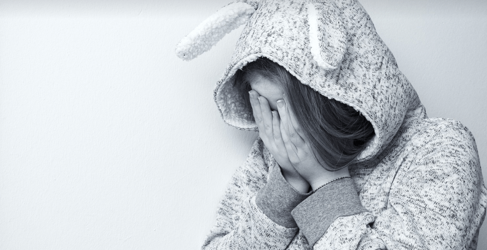 생리통으로 고통 받는 여성이 두 손으로 얼굴을 감싸고 있다