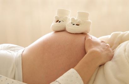 임산부 배위에 아기 신발이 놓여있는 사진
