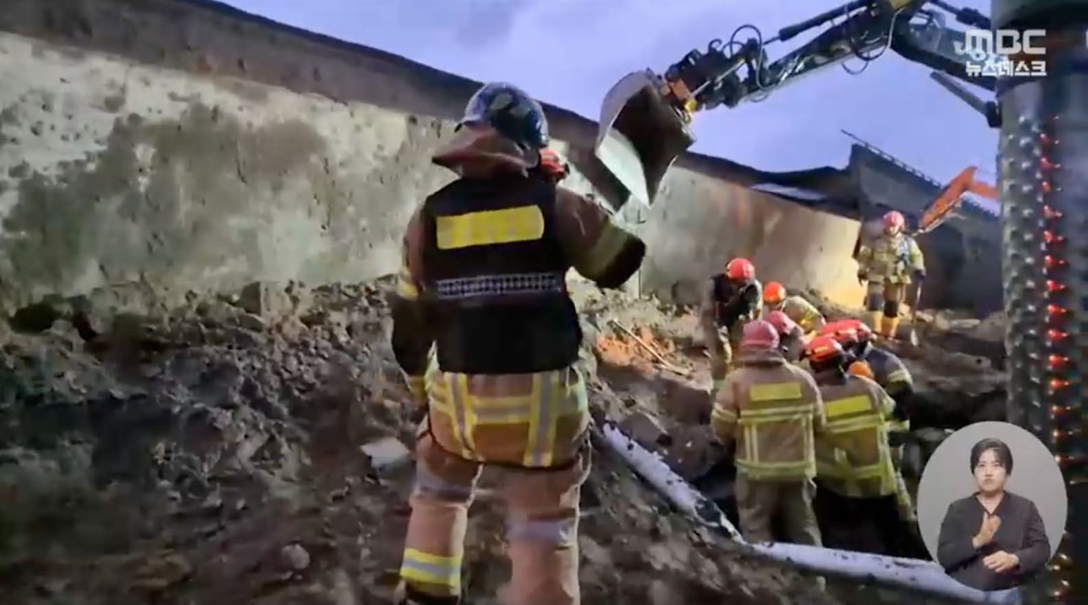 붕괴된 옹벽 잔해에 깔린 차량을 수습하는 구급대원들