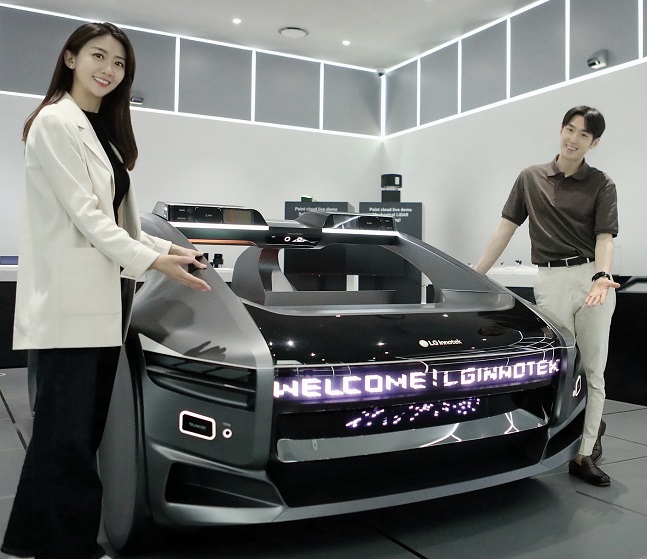 LG이노텍 직원들이 미래차 목업(Mock-up)에 장착된 차량 조명 모듈 '넥슬라이드'를 선보이고 있다.