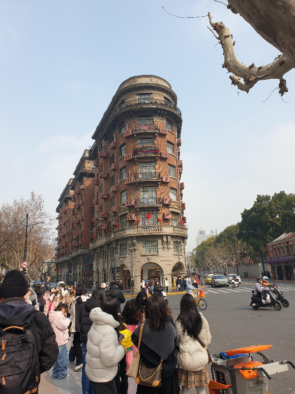 붉은 테라코타 외벽, 아치형 창문, 군데군데 보이는 녹색 덩굴식물 그리고 삼각형 꼭짓점을 가진 우캉맨션