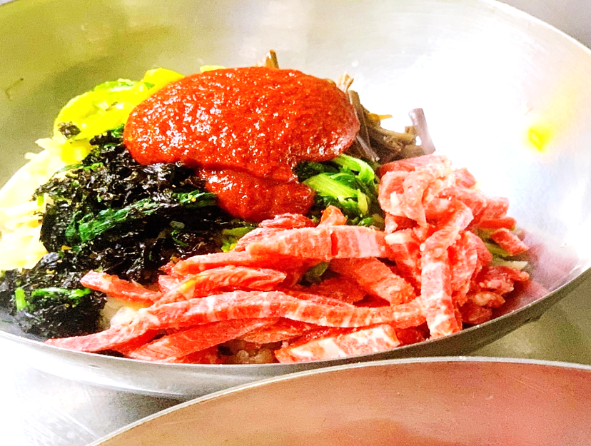 신선한 한우 육회와 비법 고추장, 그리고 제철 나물들이 고급스런 놋그릇에 가득 담겨져 있는 모습