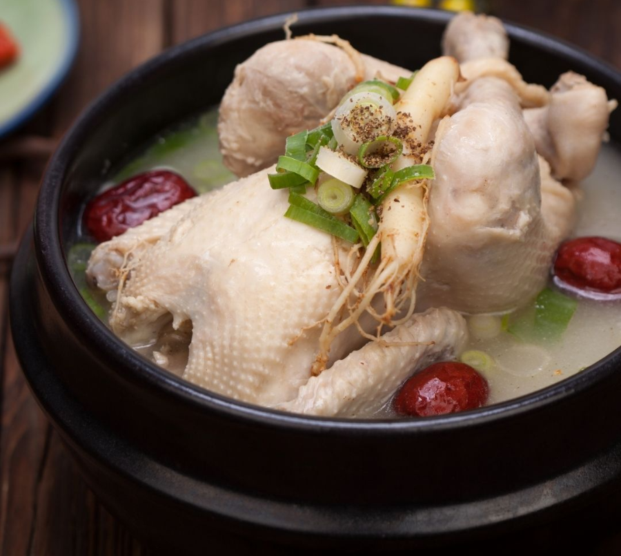 alt="갈색 뚝배기 안에 닭 한마리가 다리가 포개져 있고 중앙에는 대파와 후추, 인삼 한 뿌리가 올려져 있으며, 뽀얀 국물과 대추 2개가 있으며, 진한 갈색 빛을 띠 며는 국물 위에 떠 있는 이미지"