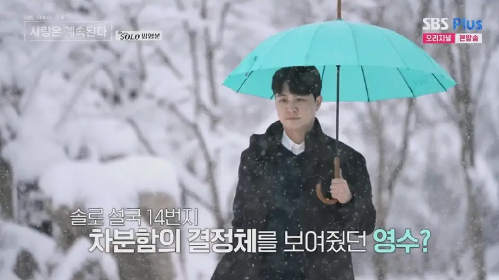 나솔사계-
파란색 우산을 들고 눈을 맞으며 검은색 바바리를 입고 걸어가는 남자