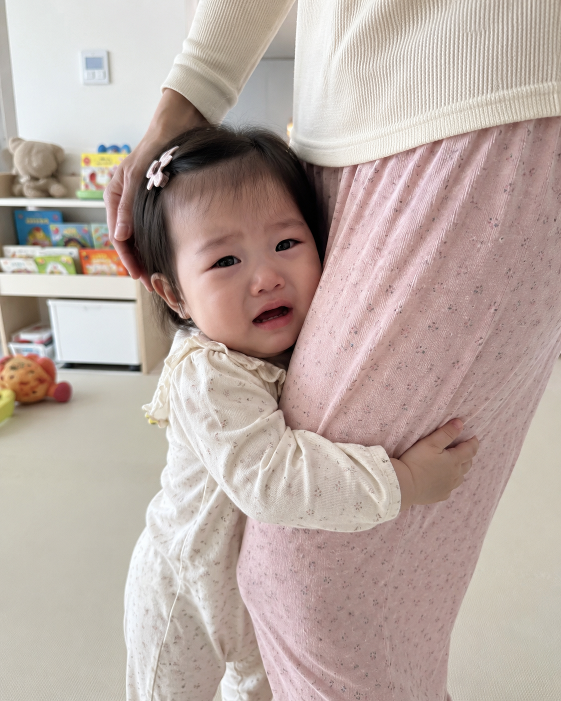 엄마에게 안아달라며 다리를 붙잡고 매달리는 12개월 한국 여자아기