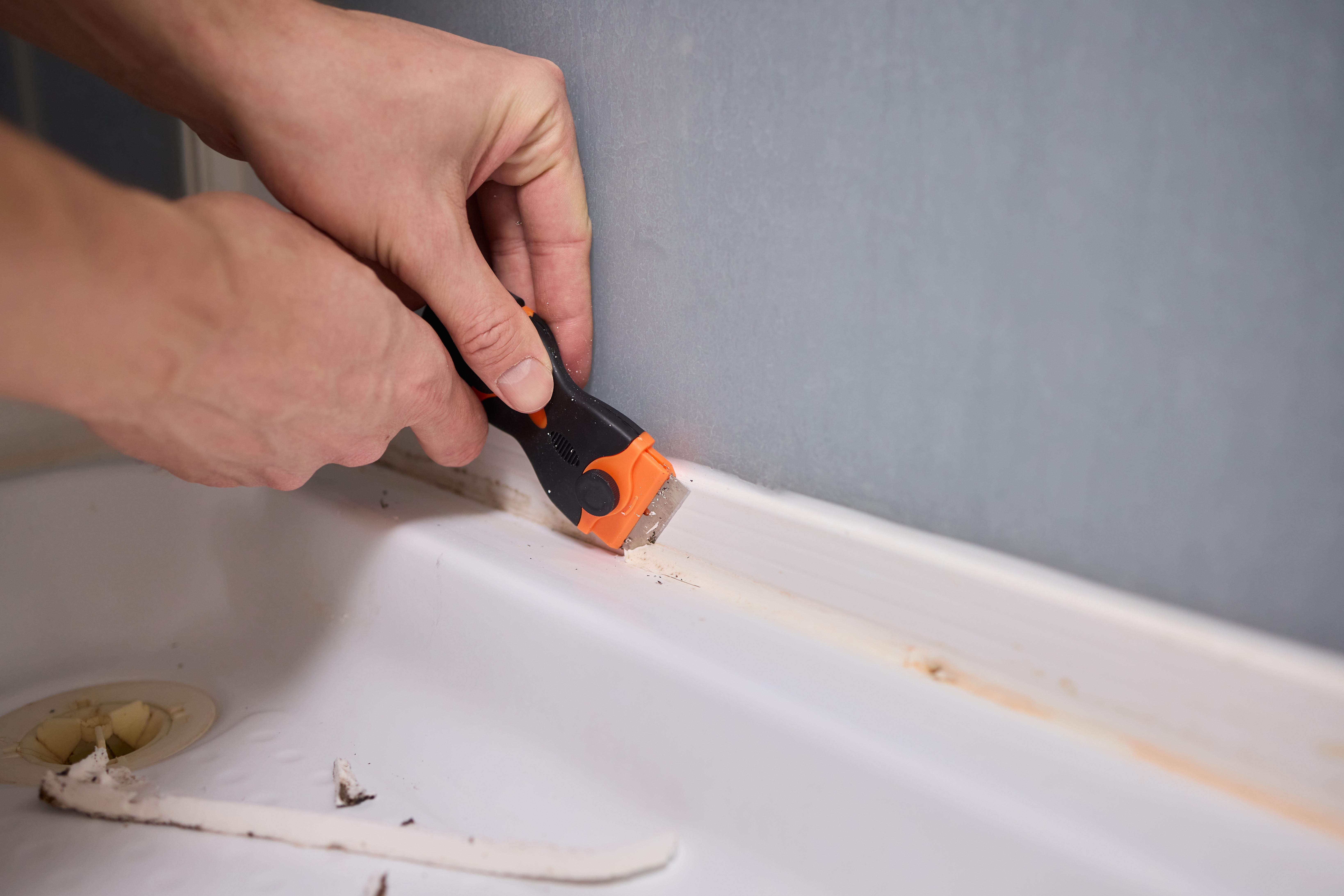 욕실 실리콘 틈의 곰팡이를 제거하기 위해 칼로 실리콘을 긁어내는 장면, 주기적인 점검과 관리 루틴