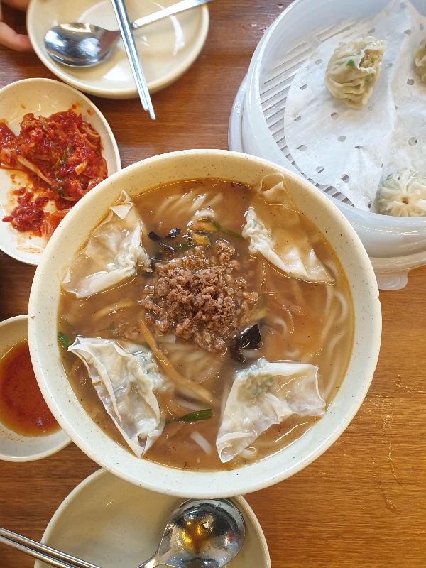 테이블 위에 명동교자 칼국수와 2개가 남은 만두