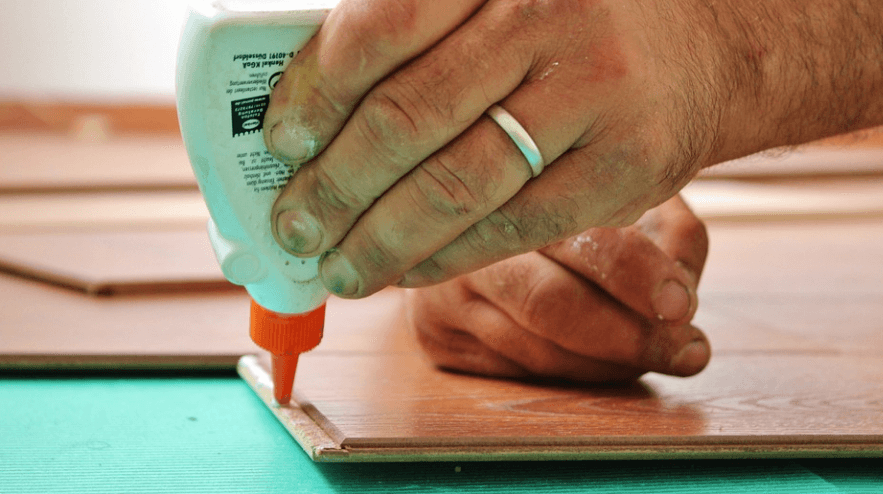 나무 판넬에 순간접착제를 바르고 있다.