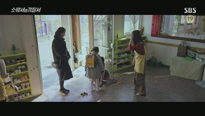 유치원에서 집에 가는 아이의 신발을 묶어주는 어머니의 사진입니다.