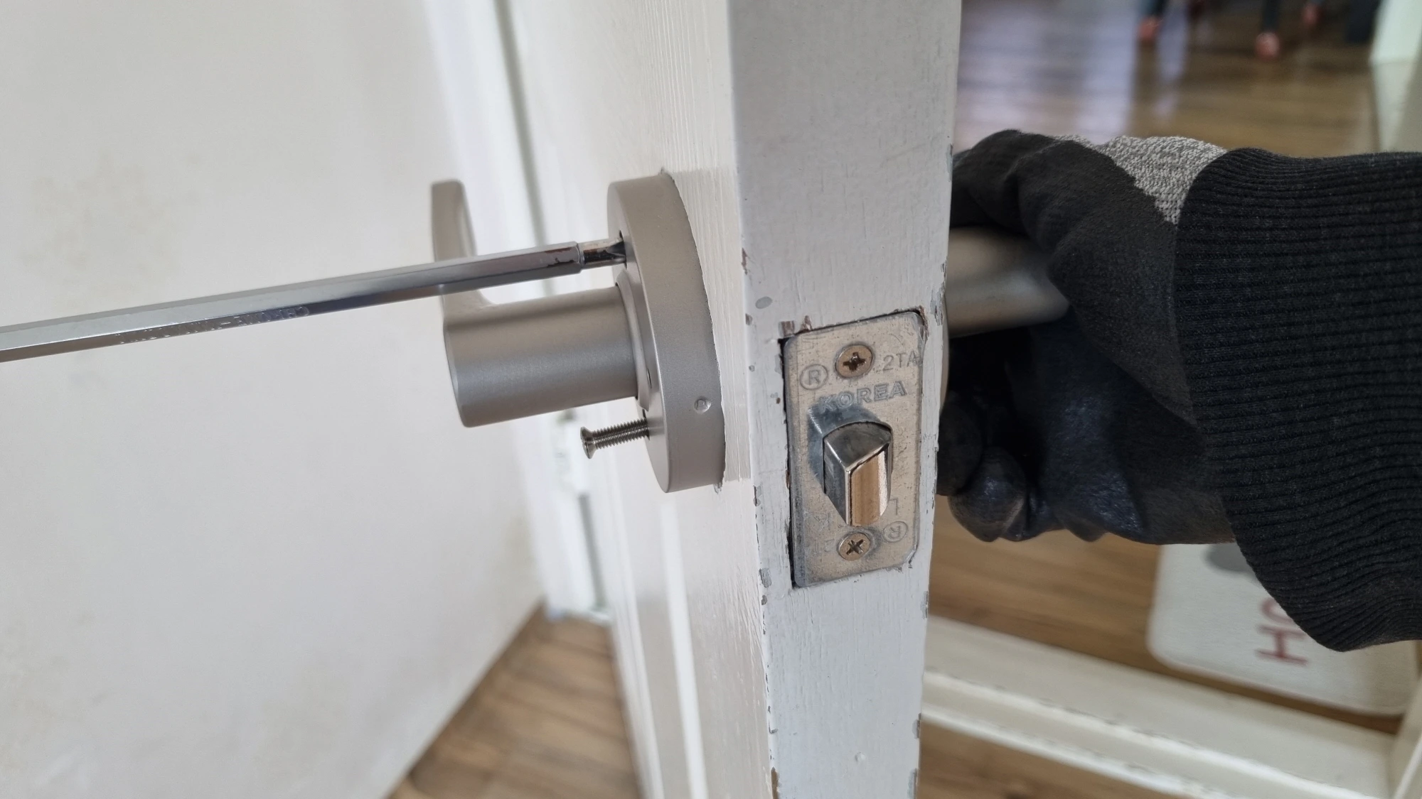 방문 손잡이 고정 볼트 조이는 모습
