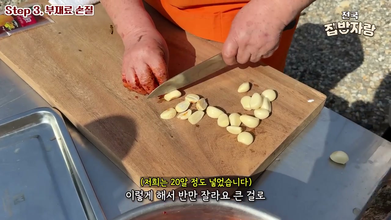 통마늘을 반으로 잘라 도마에 놓은 장면