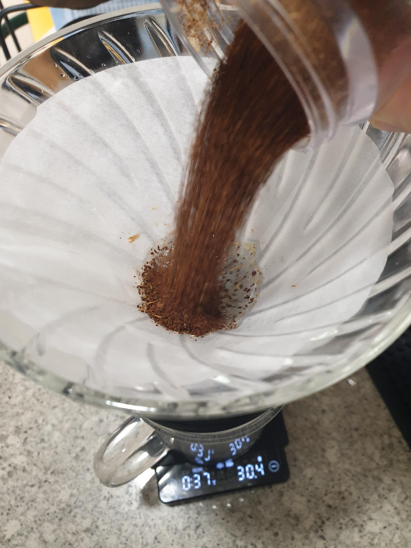38초에 원두를 붓는 모습. 원두가루를 30g의 물이 담긴 드리퍼에 붓는다.