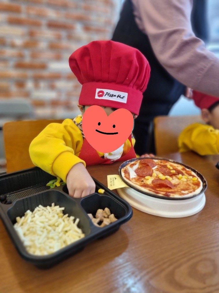 피자에 토핑을 올리는 아이