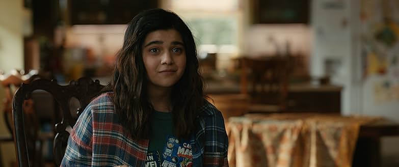 미즈 마블이 집에서 체크 셔츠를 걸치고 앉아 있는 모습