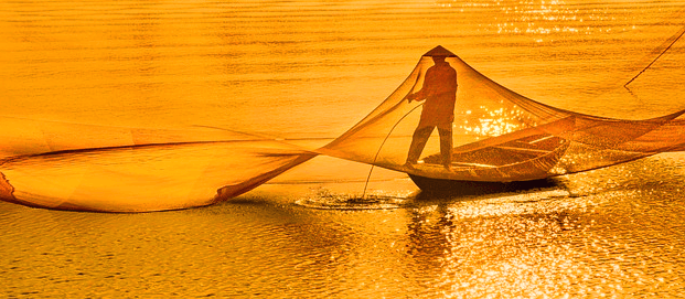 한 어부가 작은 배에 매우 넓은 바다에 그물을 치고 있다.