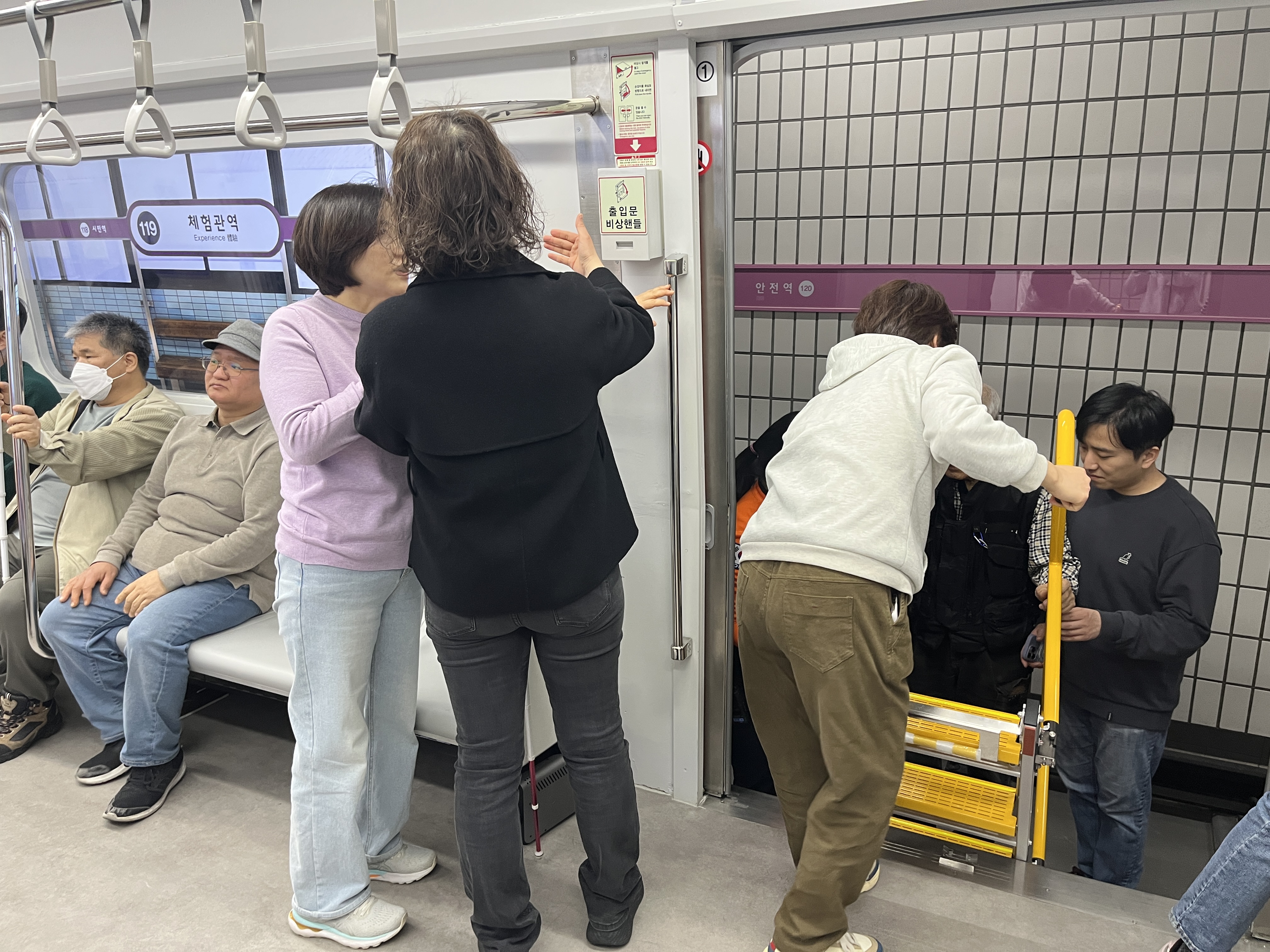 선로로 내려가기 위해 지하철에 비치된 비상사다리를 설치하고 있다.