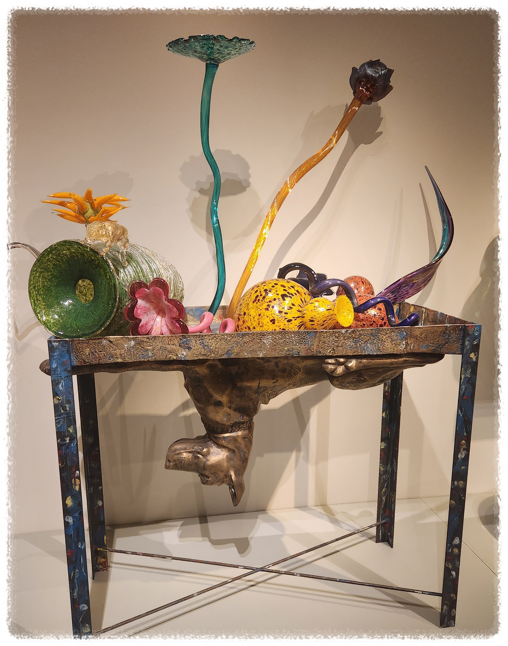 테이블 아래에는 감아지가 있고 위에는 꽃병과 꽃이 있는 이미지