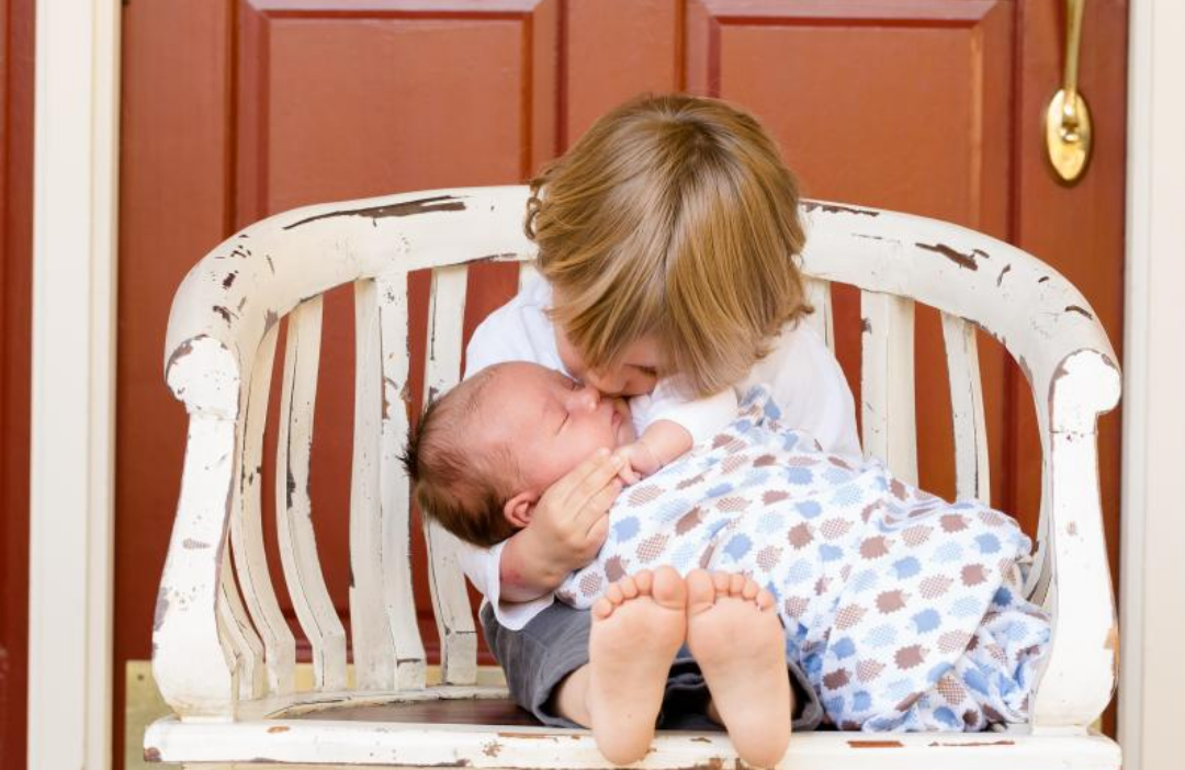 자신의 동생의 볼에 뽀뽀해주는 형