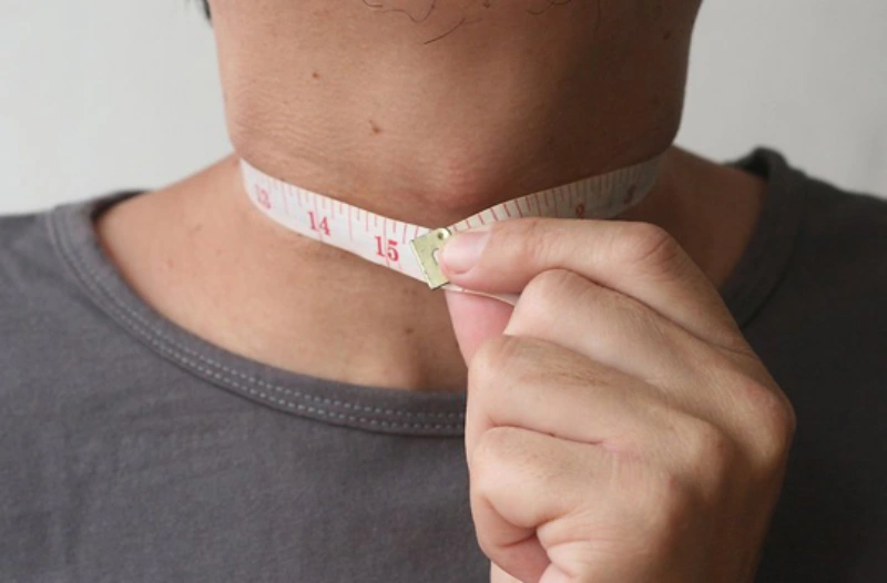 목둘레를 재고 있는 남성