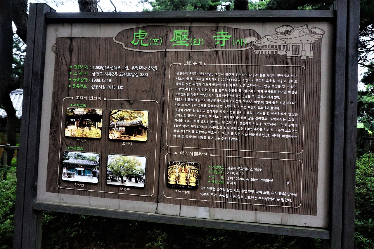 호압사 안내판, 검은 색에 가까운 나무 색깔 목재 판에 깨알같이 작은 흰글씨. 호압사, 한자 표기만 녹색,