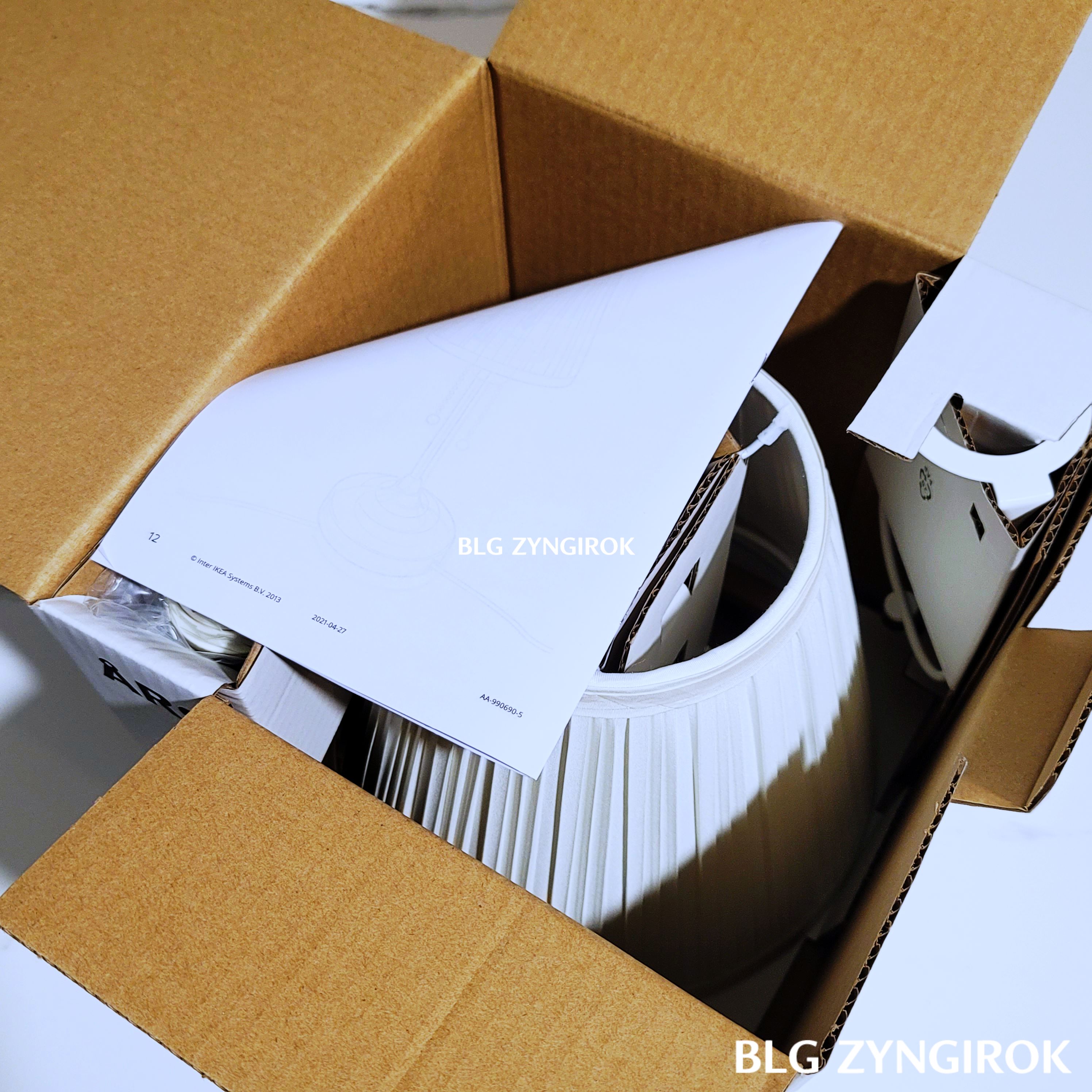 이케아-아스트리드-상자를-열었을-때-모습이다.-조명위에-설명서가-놓여있다.