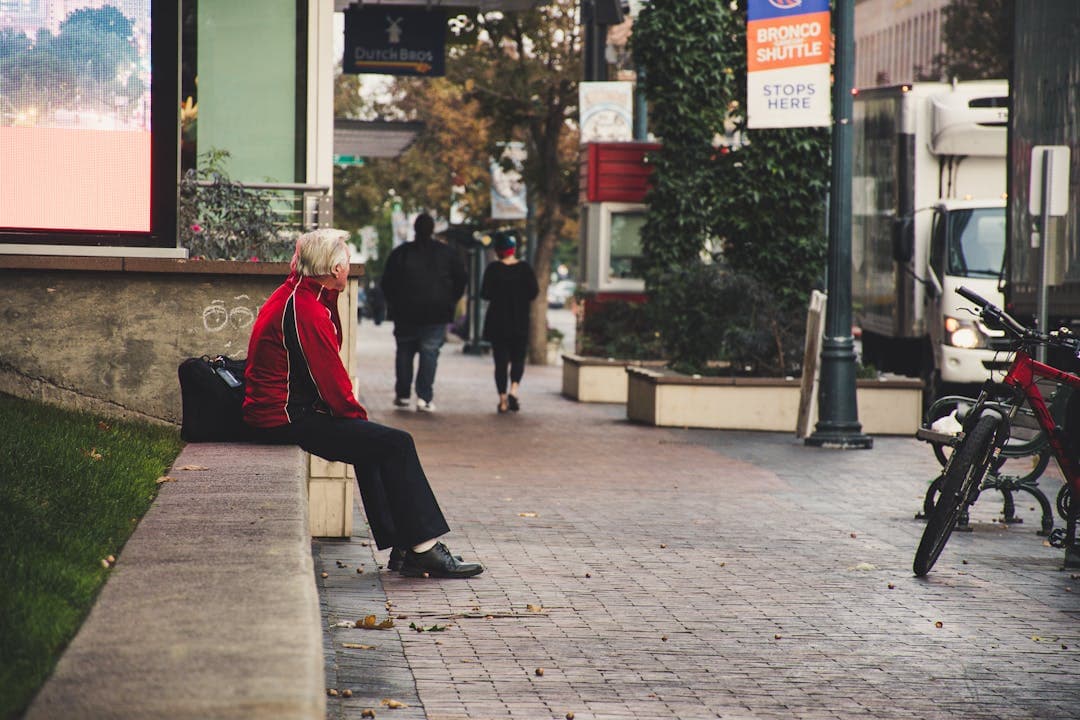 연금을 기다리며 혼자 벤치에 앉아 있는 고령자