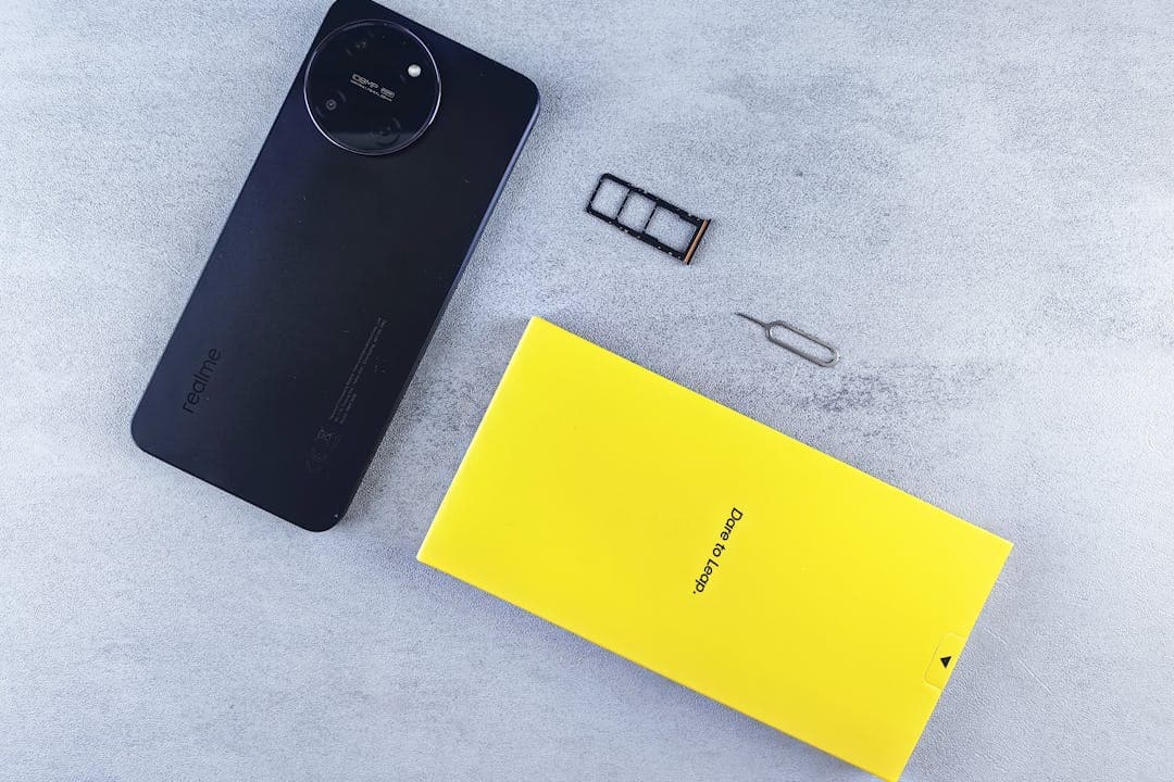 스마트폰, SIM 트레이, 핀, 박스 구성품이 함께 놓인 초기 개봉 이미지