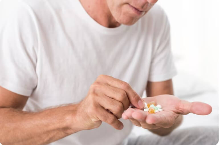 많은 약을 손바닥에 놓고 고르고 있는 남성