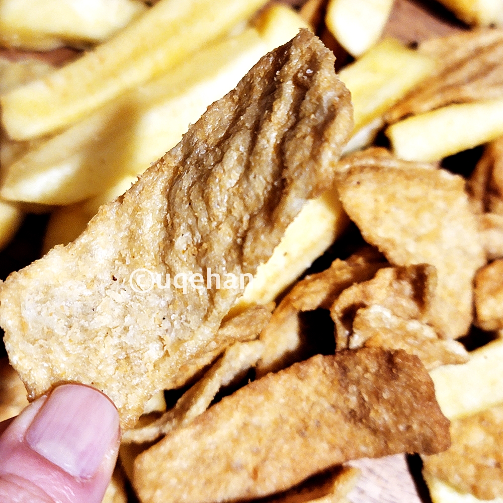 1860 조셉말린 피쉬 앤 칩스 안에 들어 있는 쥐포 튀김을 손으로 잡고 있다.