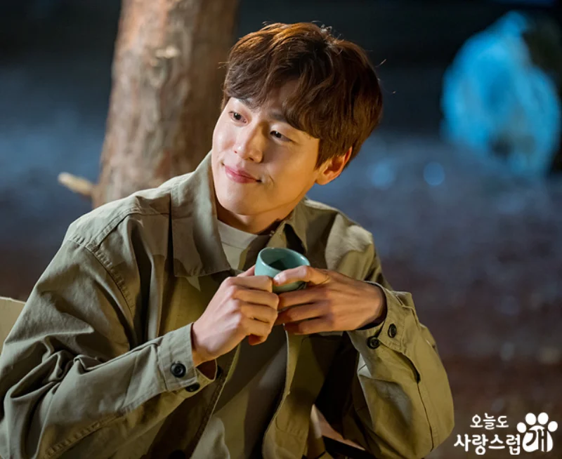 어느 야외에서 카키색 남방과 갈색 머리를 하고 있는 오늘도 사랑스럽개 출연 배우 이현우