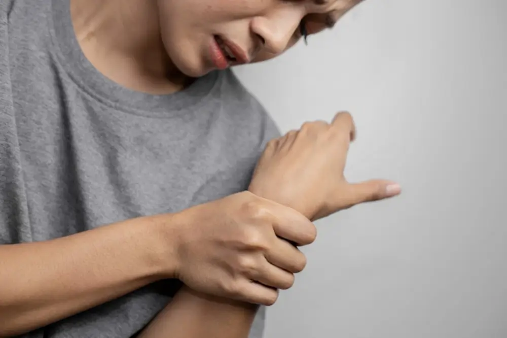 손목을 잡고 아파하는 여자