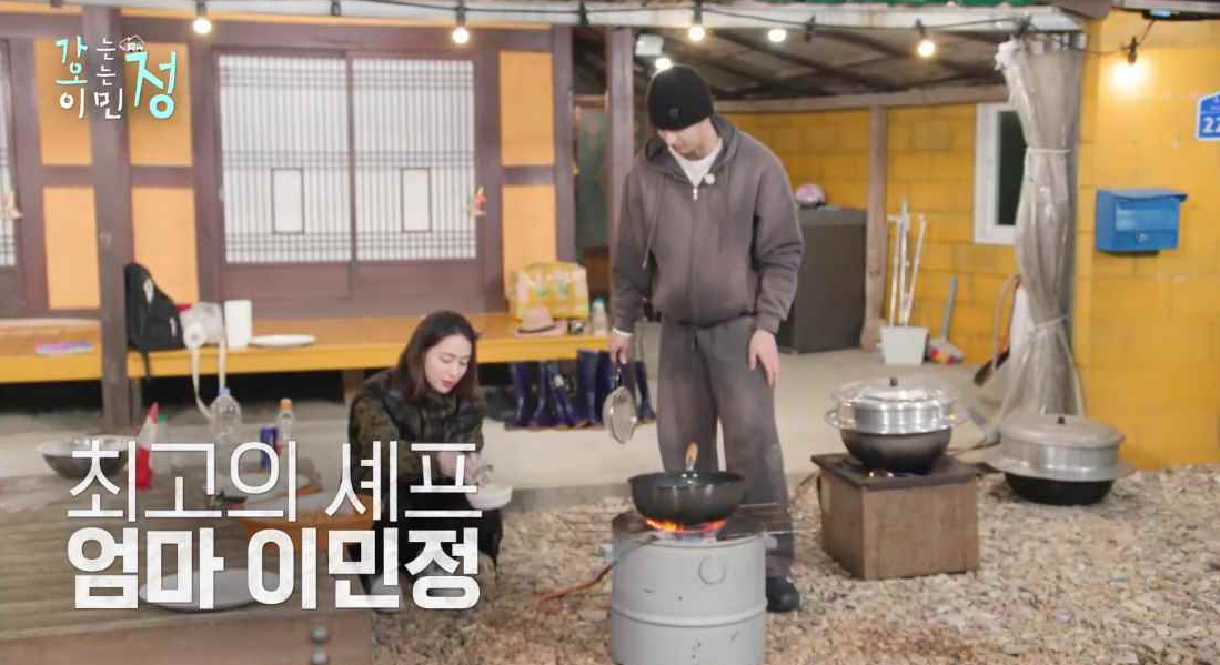 마당에서 앉아서 화덕에 저녁을 준비하는 이민정과 옆에 서있는 김재원 모습에 최고의 셰프 엄마 이민정 자막이 있는 스틸컷